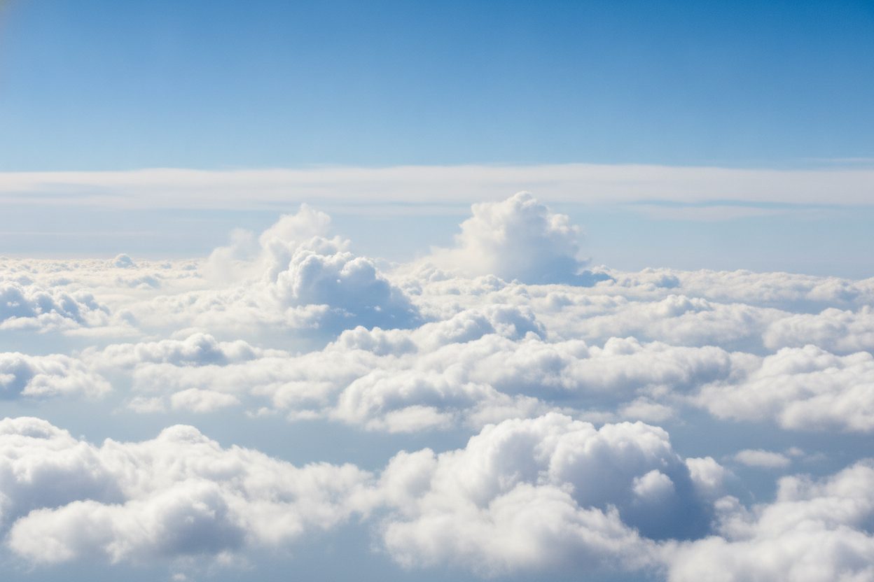 Soft white clouds against a bright blue sky at high altitude